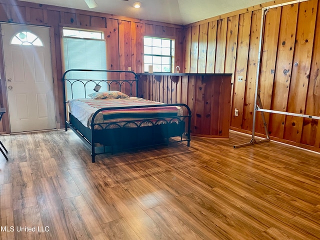 bedroom featuring wooden walls and hardwood / wood-style flooring