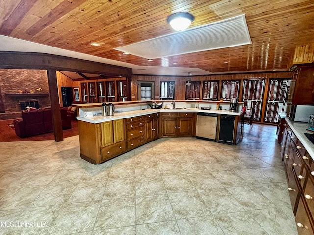 kitchen with wood walls, a large fireplace, wood ceiling, kitchen peninsula, and stainless steel dishwasher