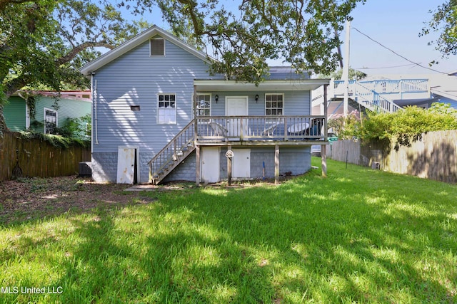 rear view of house featuring a yard and a deck