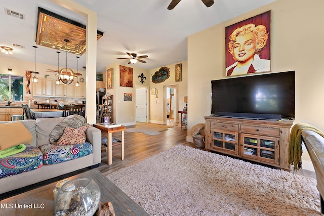 living room featuring sink, hardwood / wood-style flooring, and ceiling fan with notable chandelier