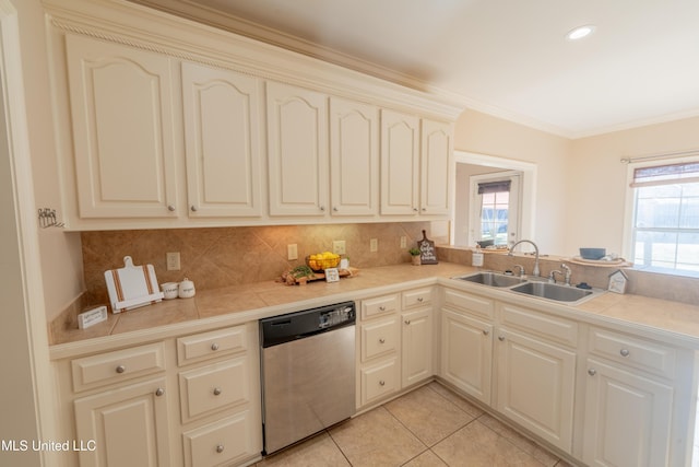 kitchen featuring a sink, tasteful backsplash, stainless steel dishwasher, and a wealth of natural light