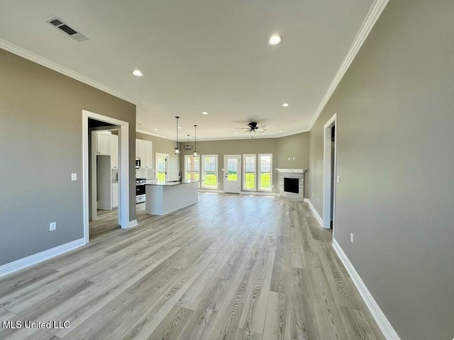 113 River Bend Ave, Vidalia, LA 71373 - unfurnished living room with a fireplace with raised hearth, light wood-style flooring, visible vents, baseboards, and ornamental molding