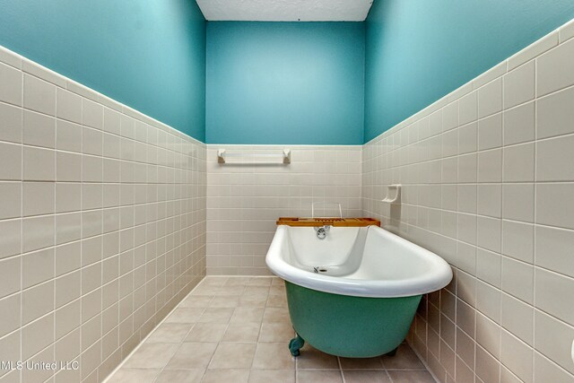 106 Mcwilliams Dr, Terry, MS 39170 - full bathroom with tile walls, a soaking tub, tile patterned floors, and wainscoting