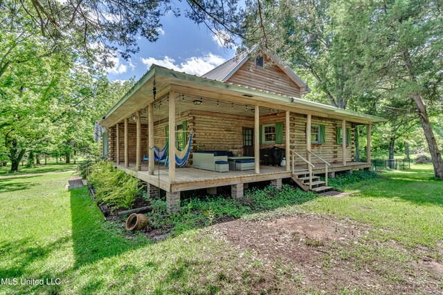 106 Mcwilliams Dr, Terry, MS 39170 - back of property with log siding, a lawn, metal roof, and a wooden deck