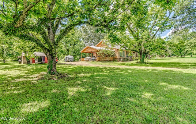 106 Mcwilliams Dr, Terry, MS 39170 - view of green lawn featuring an outbuilding, a storage unit, and a carport