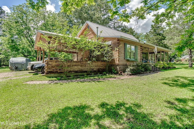106 Mcwilliams Dr, Terry, MS 39170 - view of side of home featuring log exterior, a yard, metal roof, and covered porch