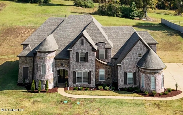 french country inspired facade with a front yard