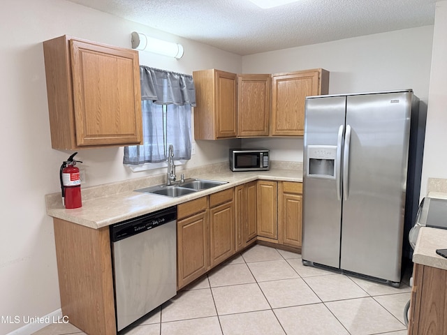 3908 Wildwood Rd, Moss Point, MS 39562 - kitchen featuring stainless steel appliances, light countertops, light tile patterned flooring, and a textured ceiling