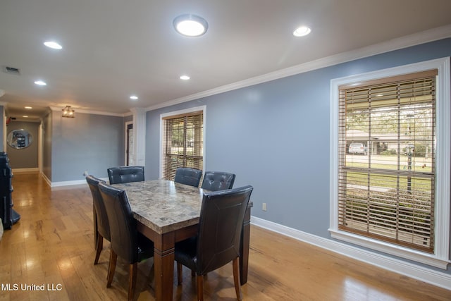 dining area featuring ornamental molding and light wood-type flooring