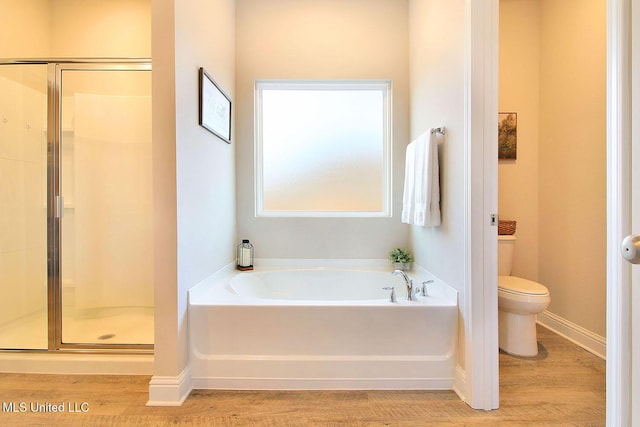 bathroom with hardwood / wood-style flooring, plus walk in shower, and toilet