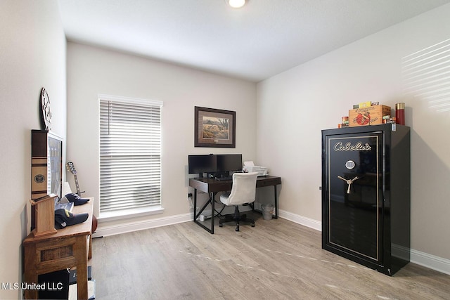 home office with light hardwood / wood-style floors