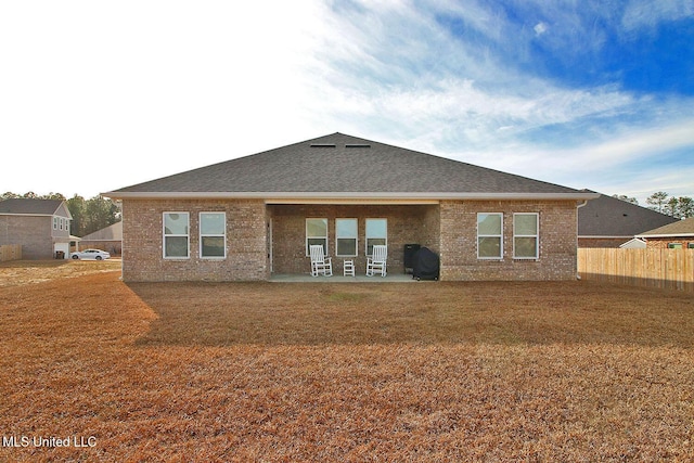 rear view of property featuring a patio and a yard