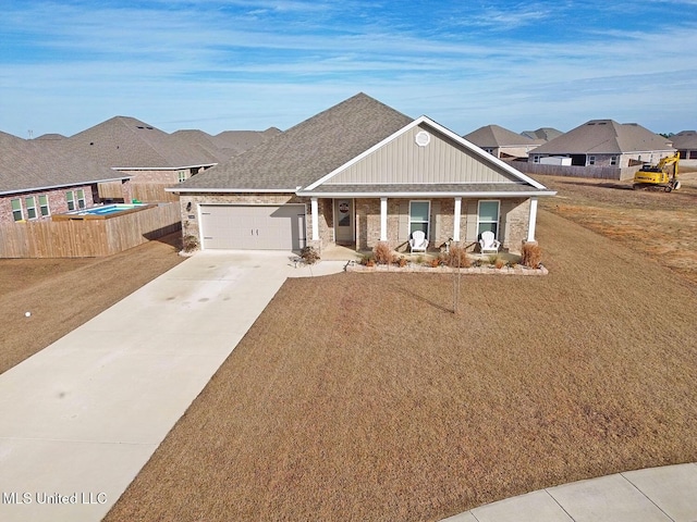 view of front of house with a garage, a front lawn, and covered porch