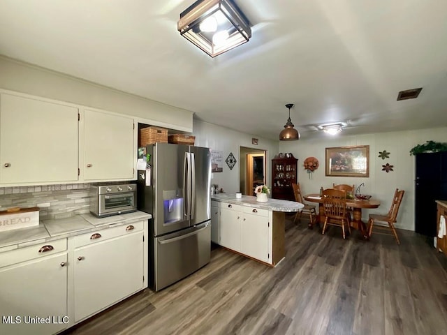 kitchen with white cabinets, stainless steel fridge, dark hardwood / wood-style flooring, and kitchen peninsula