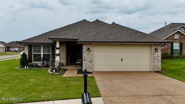 2490 Marion Ln, Southaven, MS 38672 - ranch-style home with an attached garage, concrete driveway, roof with shingles, and a front yard