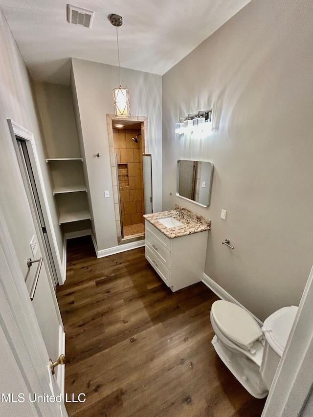 full bath with toilet, wood finished floors, visible vents, and a stall shower