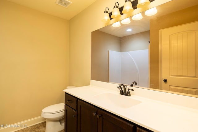 bathroom featuring toilet, vanity, and tile patterned flooring