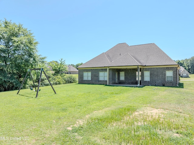 rear view of house featuring a lawn