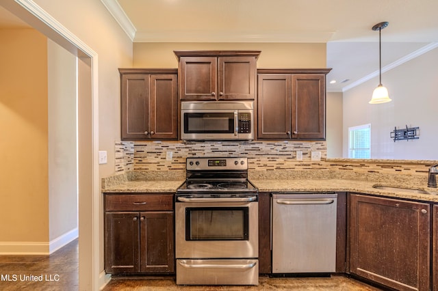 kitchen with sink, crown molding, hanging light fixtures, and stainless steel appliances