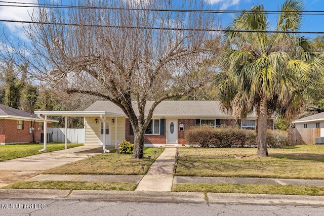 view of front of home with concrete driveway, an attached carport, fence, a front yard, and brick siding