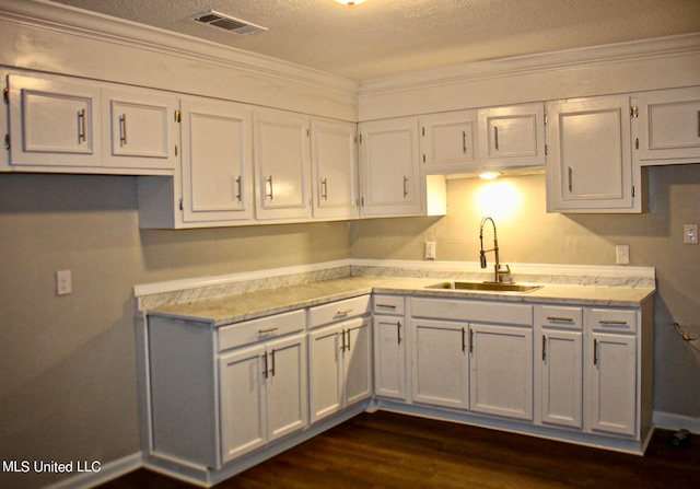 kitchen featuring crown molding, sink, and white cabinets