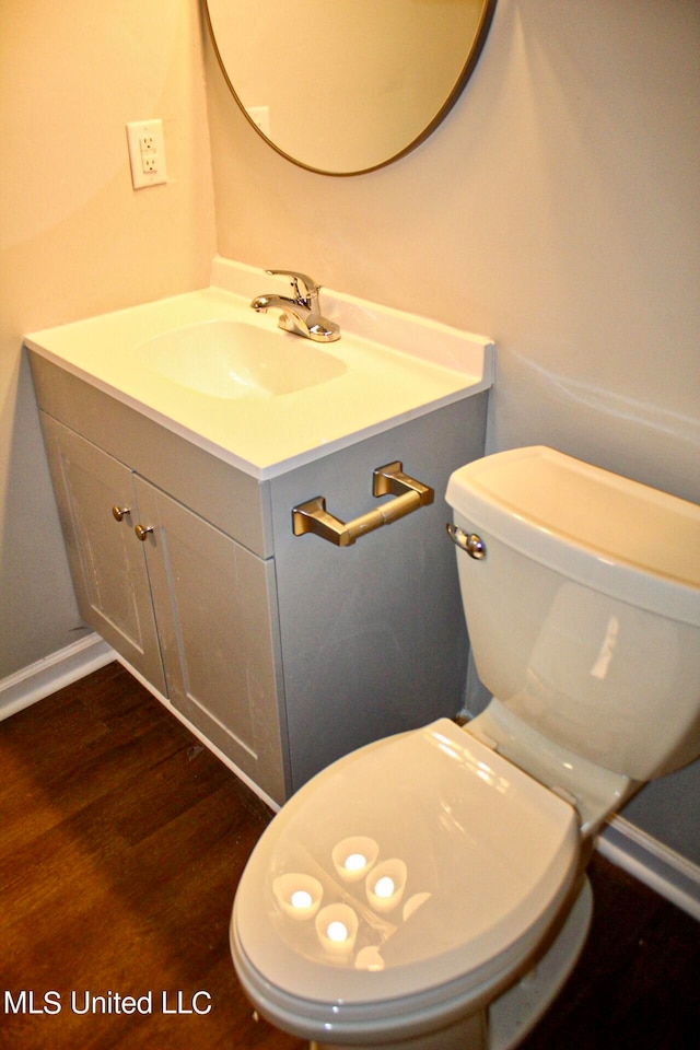 bathroom with vanity, toilet, and wood-type flooring