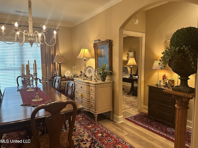 6819 Hawks Vw, Olive Branch, MS 38654 - dining space with arched walkways, a chandelier, light wood-type flooring, and ornamental molding