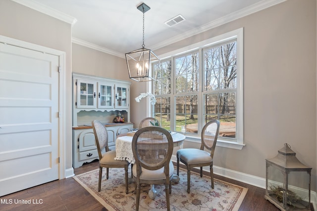 dining room with dark wood finished floors, baseboards, a chandelier, and ornamental molding