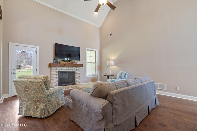 living area with high vaulted ceiling, dark wood-style floors, baseboards, a brick fireplace, and ceiling fan