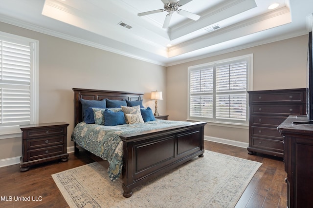 bedroom with visible vents, a raised ceiling, dark wood-type flooring, and baseboards