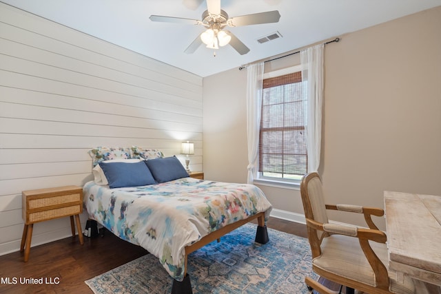 bedroom with ceiling fan, wood finished floors, visible vents, and baseboards