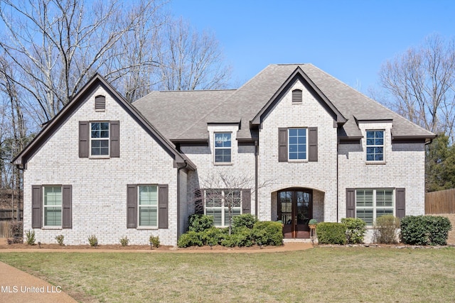 view of front of house featuring french doors, a shingled roof, and a front yard