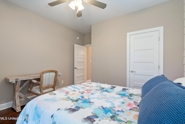 bedroom featuring baseboards, dark wood-type flooring, and a ceiling fan