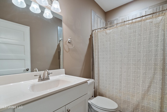 bathroom with curtained shower, toilet, and vanity