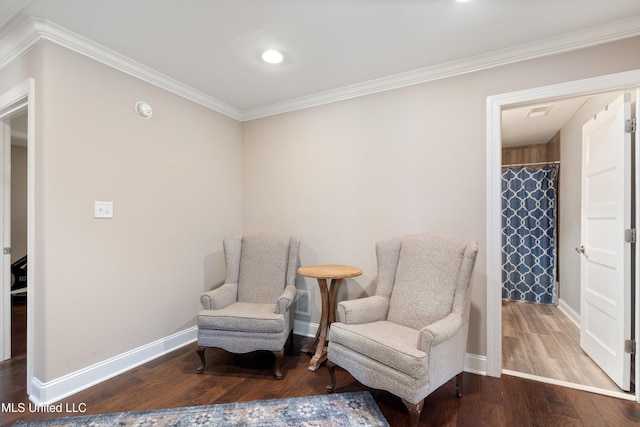 living area with baseboards, wood finished floors, and crown molding