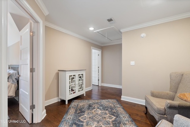 living area with visible vents, attic access, wood finished floors, and ornamental molding