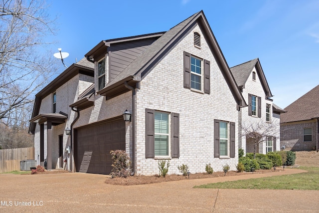 view of home's exterior featuring fence, driveway, roof with shingles, central AC, and brick siding