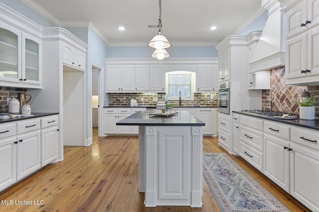 191 N Brandon Blvd, Brandon, MS 39042 - kitchen with dark countertops, oven, white cabinetry, custom range hood, and crown molding