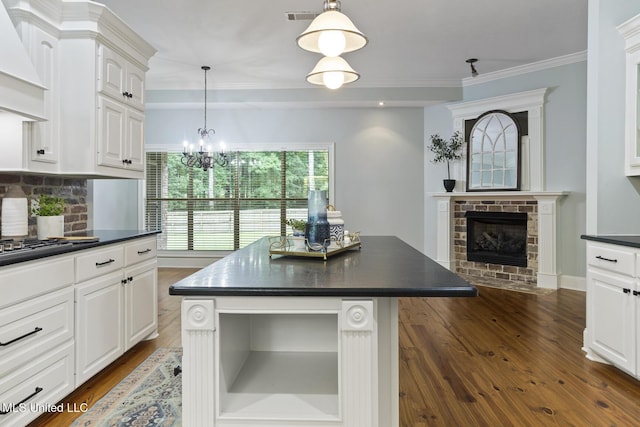 191 N Brandon Blvd, Brandon, MS 39042 - kitchen featuring dark countertops, open shelves, dark wood-type flooring, custom exhaust hood, and a chandelier
