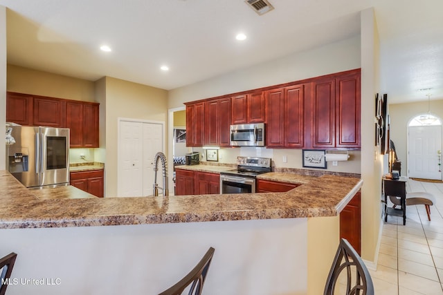 kitchen with visible vents, appliances with stainless steel finishes, and dark brown cabinets