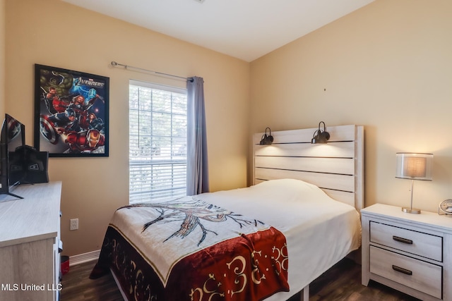 bedroom with baseboards and dark wood finished floors