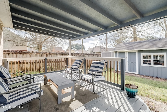 wooden terrace featuring an outbuilding, a fenced backyard, a yard, and a storage shed