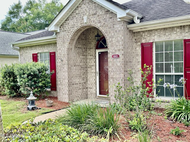6901 N Rue Mornay, Biloxi, MS 39532 - property entrance featuring roof with shingles, brick siding, and an attached garage