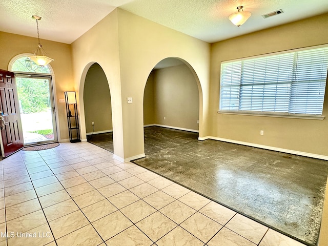 6901 N Rue Mornay, Biloxi, MS 39532 - foyer entrance featuring plenty of natural light, a textured ceiling, arched walkways, and concrete flooring