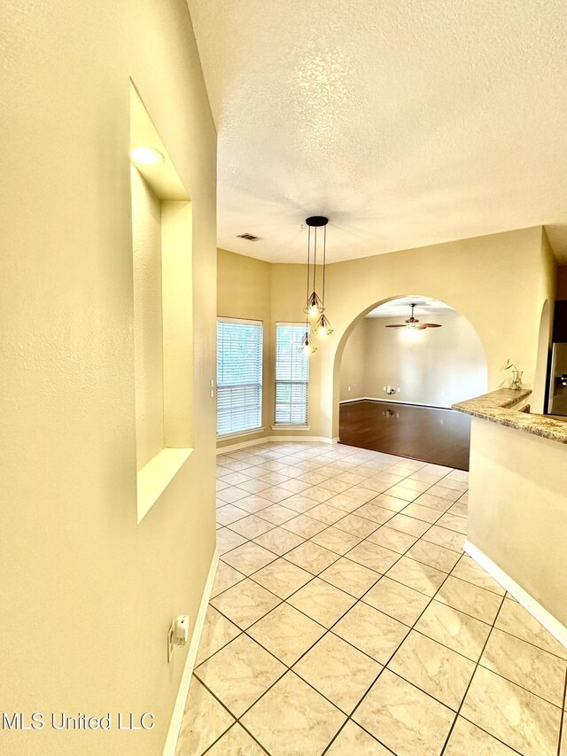 6901 N Rue Mornay, Biloxi, MS 39532 - corridor featuring arched walkways, light tile patterned floors, and a textured ceiling