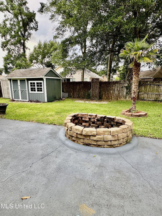 6901 N Rue Mornay, Biloxi, MS 39532 - fenced backyard featuring a fire pit, a patio, and an outdoor structure