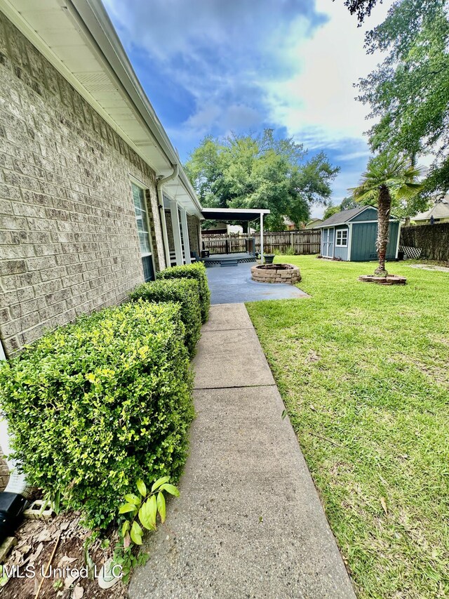 6901 N Rue Mornay, Biloxi, MS 39532 - fenced backyard featuring an outbuilding, a patio, and a fire pit