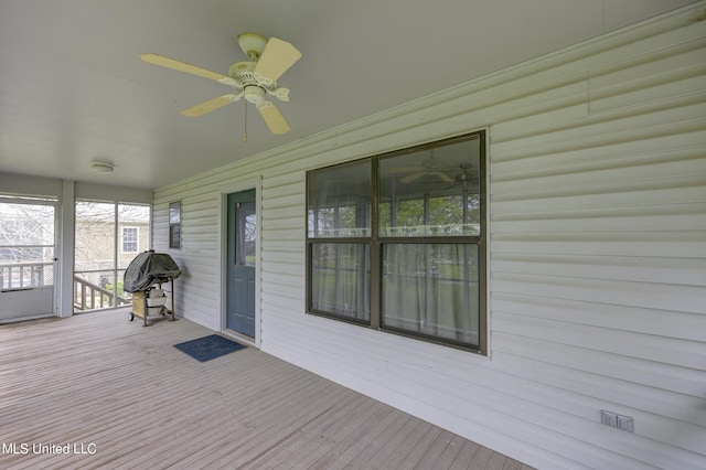 wooden deck with ceiling fan and grilling area