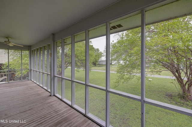 unfurnished sunroom with ceiling fan