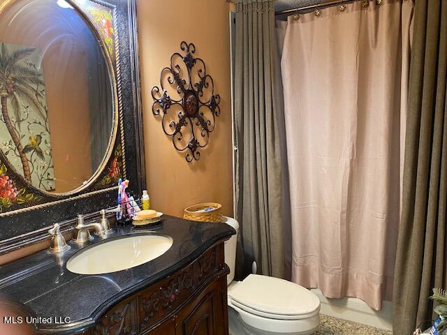 bathroom featuring vanity, a shower with shower curtain, and toilet